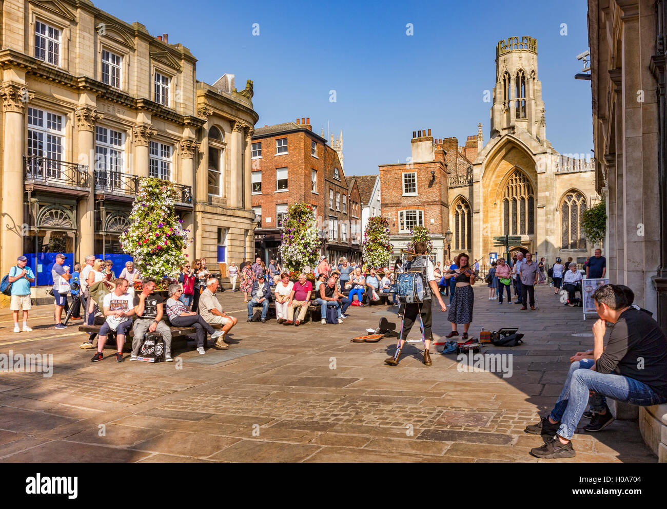 Menschenmassen beobachten, ein Mann Band Straßenmusik in St Helen's Square, York, North Yorkshire, England, UK Stockfoto