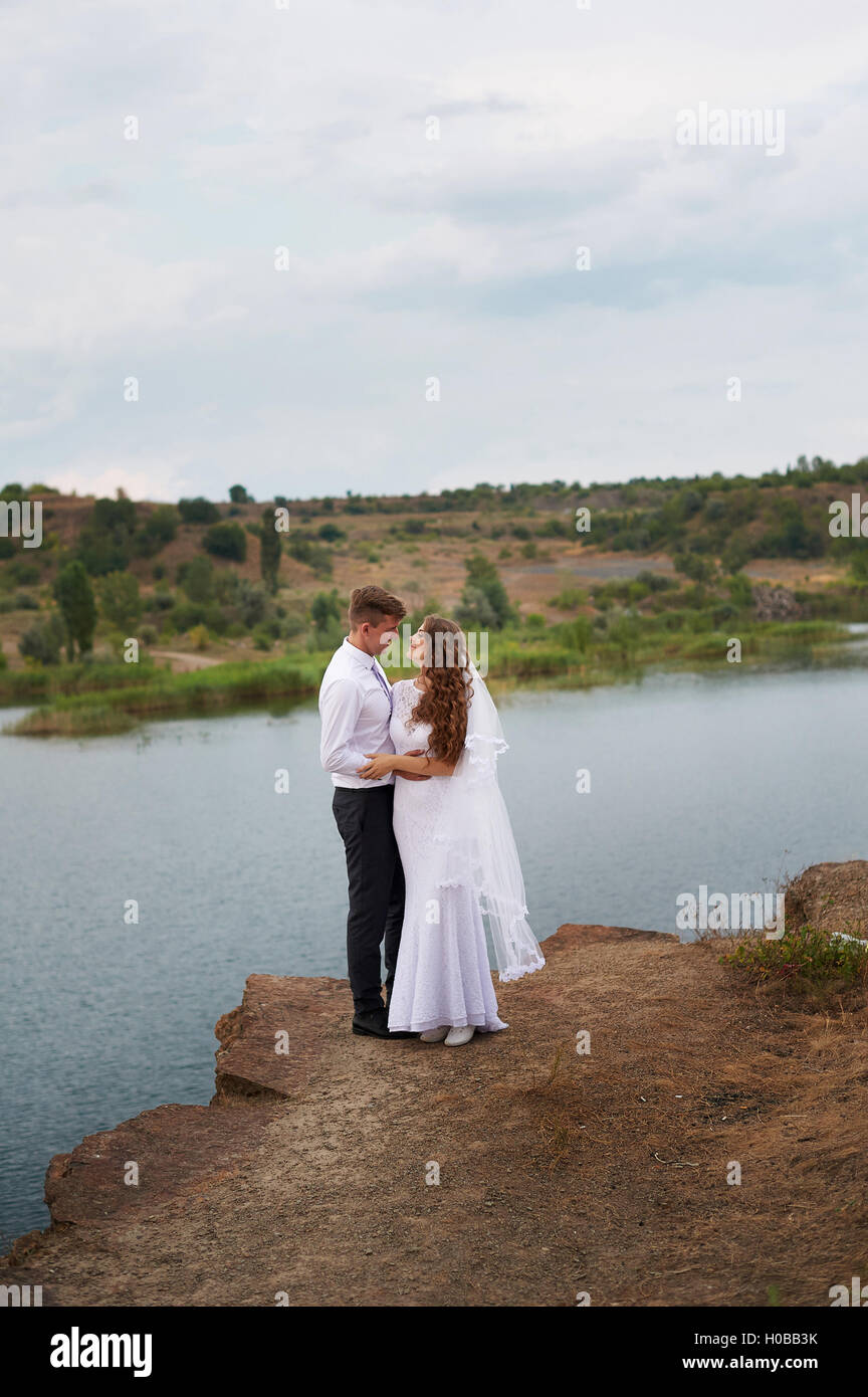 liebende Braut und Bräutigam zu Fuß auf einem Hintergrund von See Stockfoto