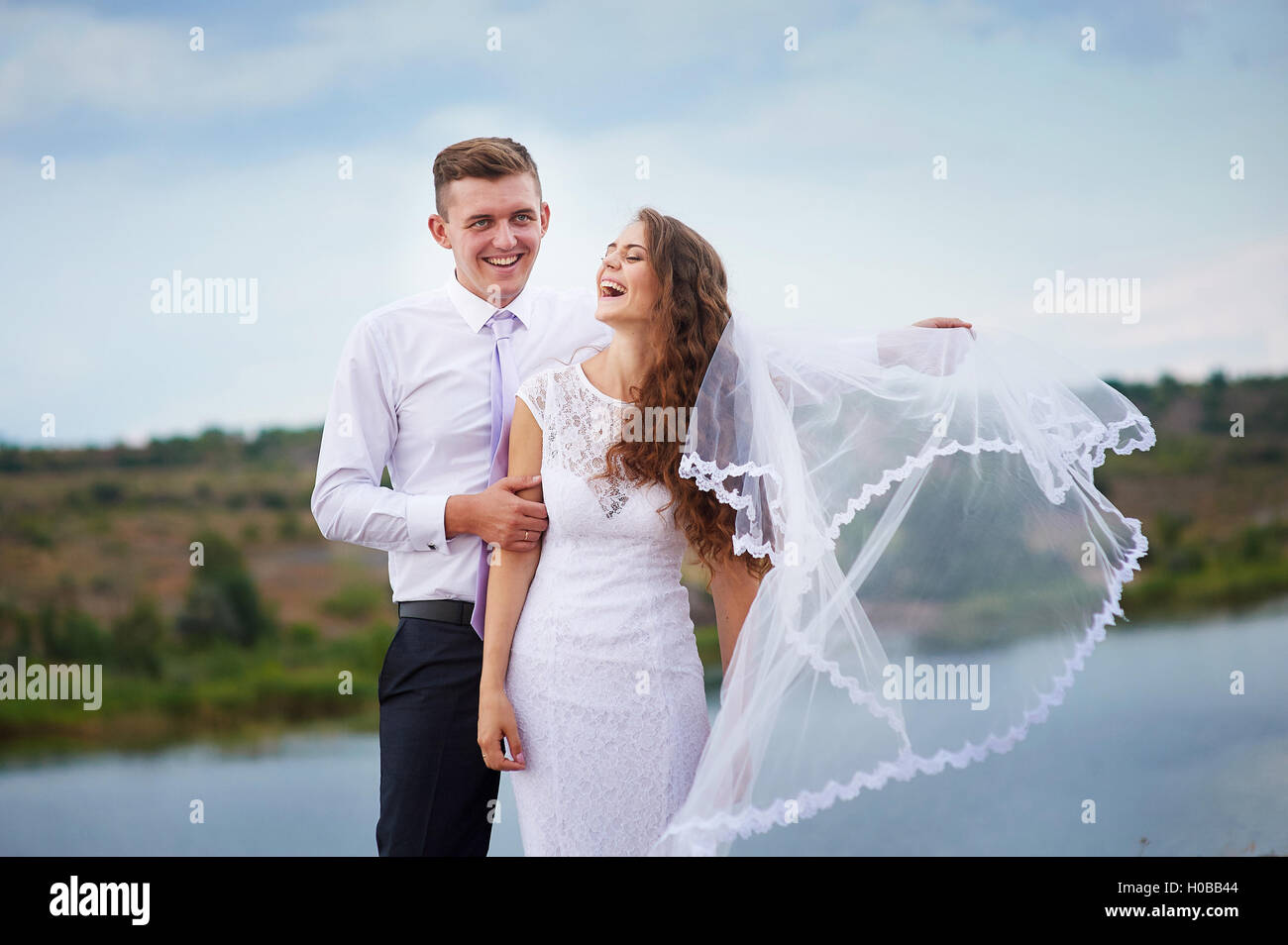 liebende Braut und Bräutigam zu Fuß auf einem Hintergrund von See Stockfoto