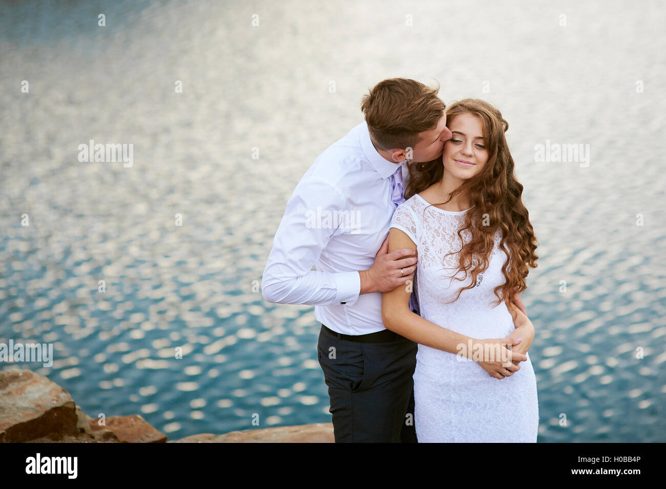 liebende Braut und Bräutigam zu Fuß auf einem Hintergrund von See Stockfoto