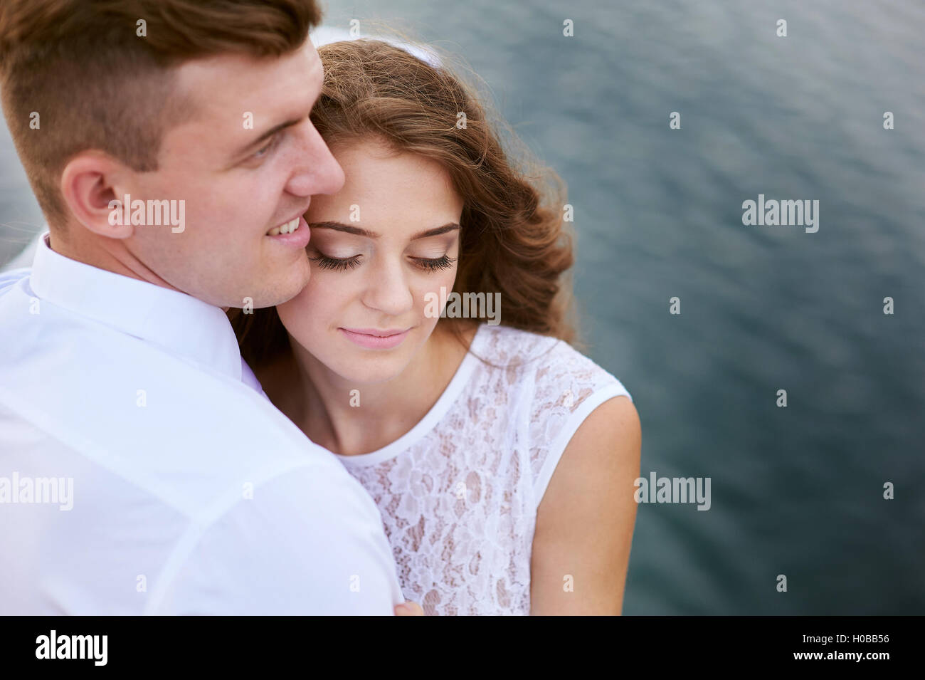 liebende Braut und Bräutigam zu Fuß auf einem Hintergrund von See Stockfoto