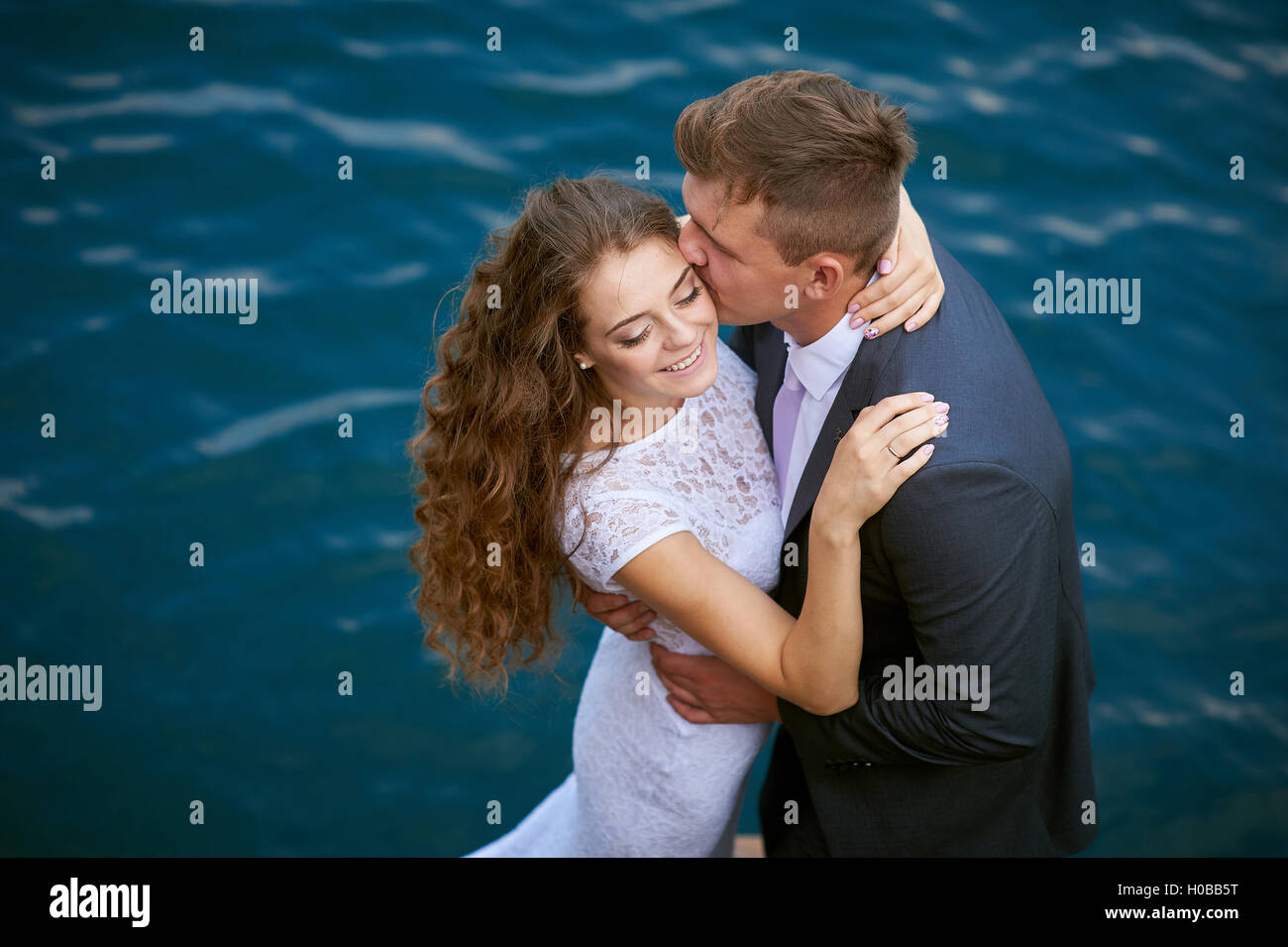 liebende Braut und Bräutigam zu Fuß auf einem Hintergrund von See Stockfoto