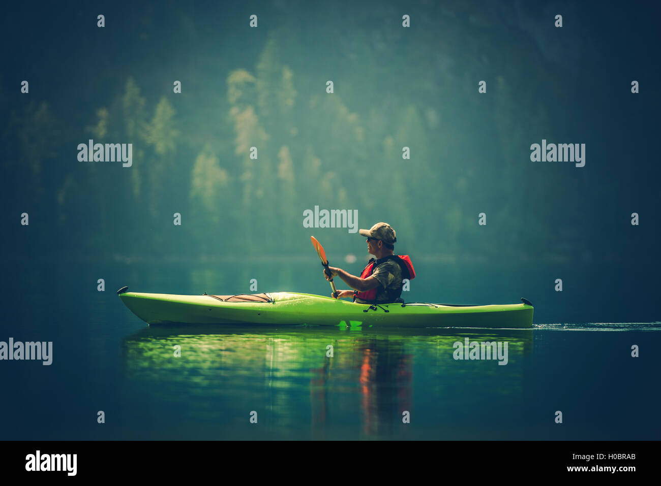 Kajak-Tour auf dem See. Mittleren Alters kaukasischen Männer im Kajak auf dem malerischen See. Stockfoto