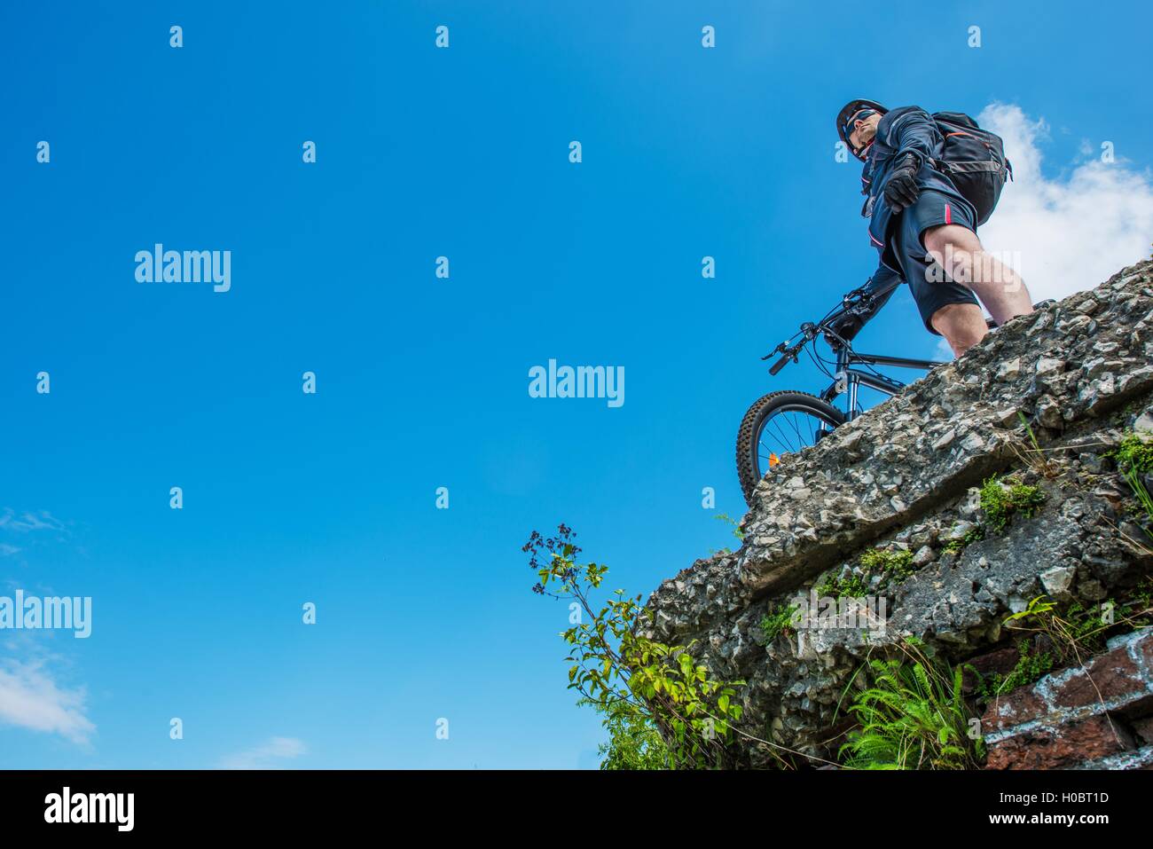 Ultimative Bike Riding Konzept Foto. Kaukasische Sportler Biker am Rande des städtischen Ruinen auf seinem Mountainbike. Stockfoto