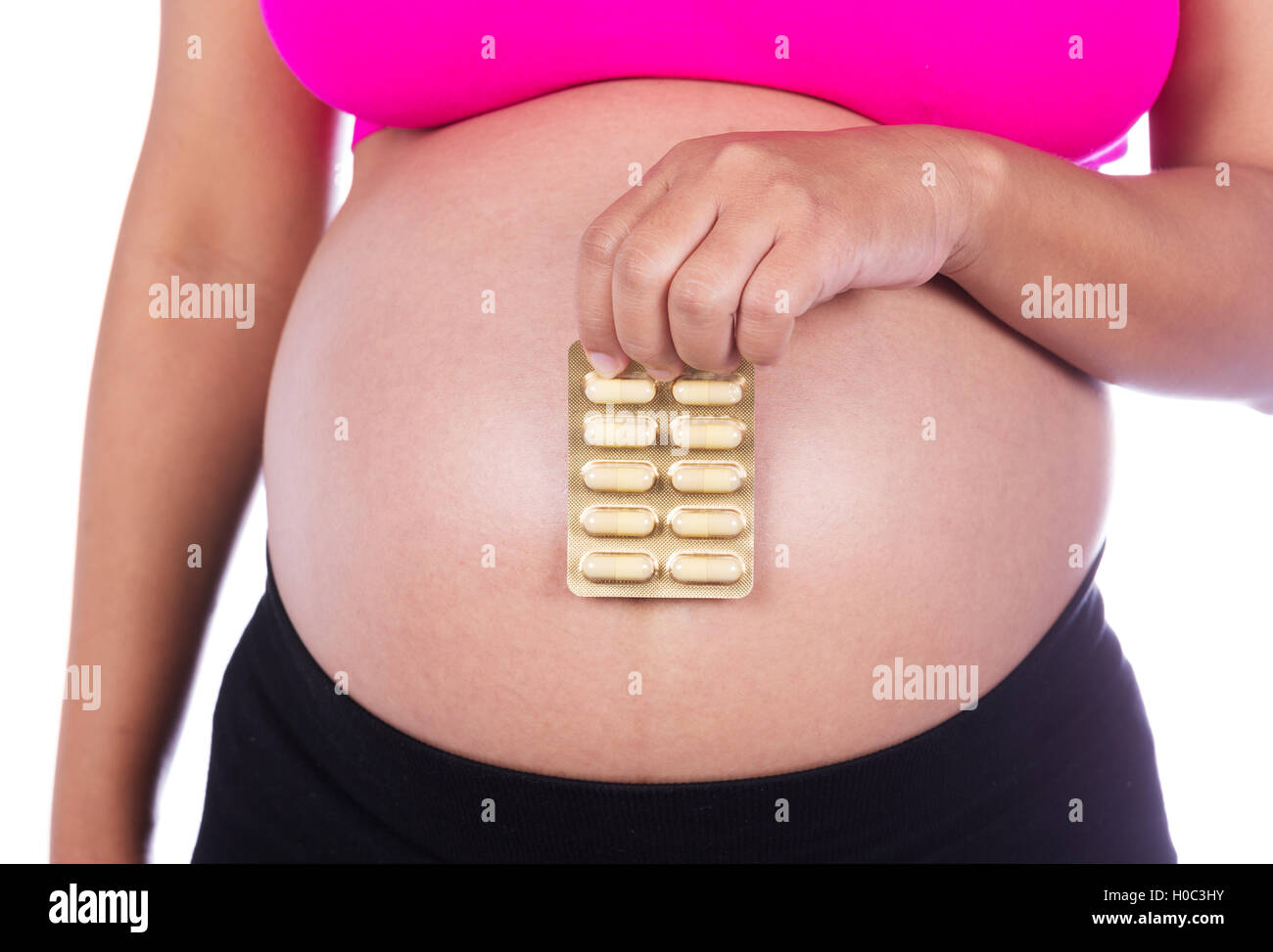 Schwangere Frau mit Packung Pillen in ihren Händen isoliert auf weißem Hintergrund Stockfoto