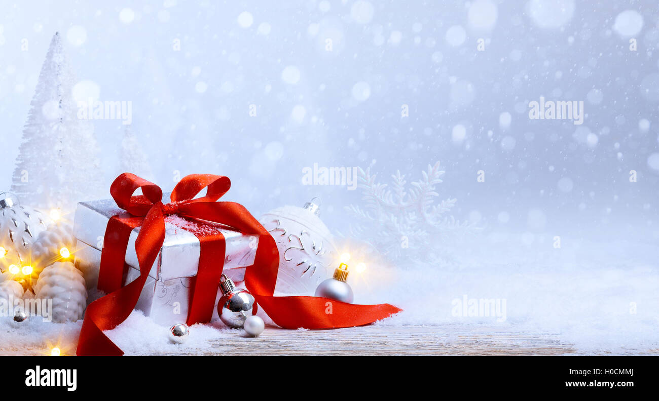 Weihnachtsbaum-Licht; festlichen Hintergrund mit Christbaumkugeln und Geschenk-Box auf Schnee Stockfoto