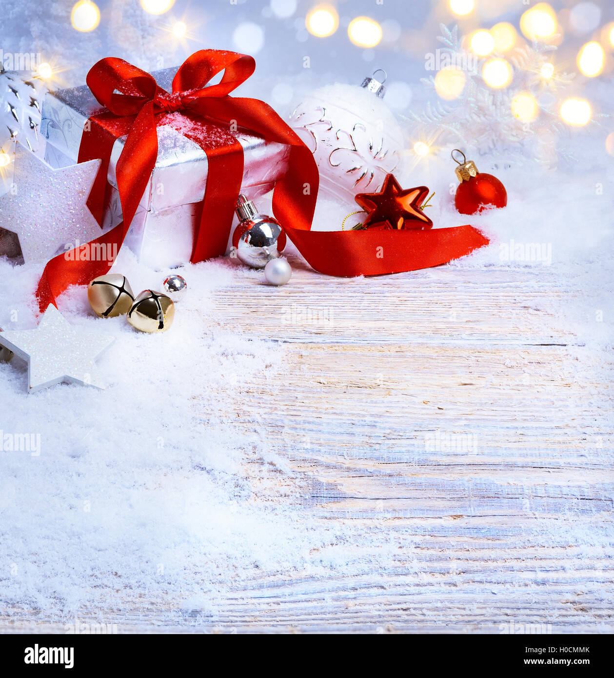 Weihnachtsbaum-Licht; festlichen Hintergrund mit Christbaumkugeln und Geschenk-Box auf Schnee Stockfoto