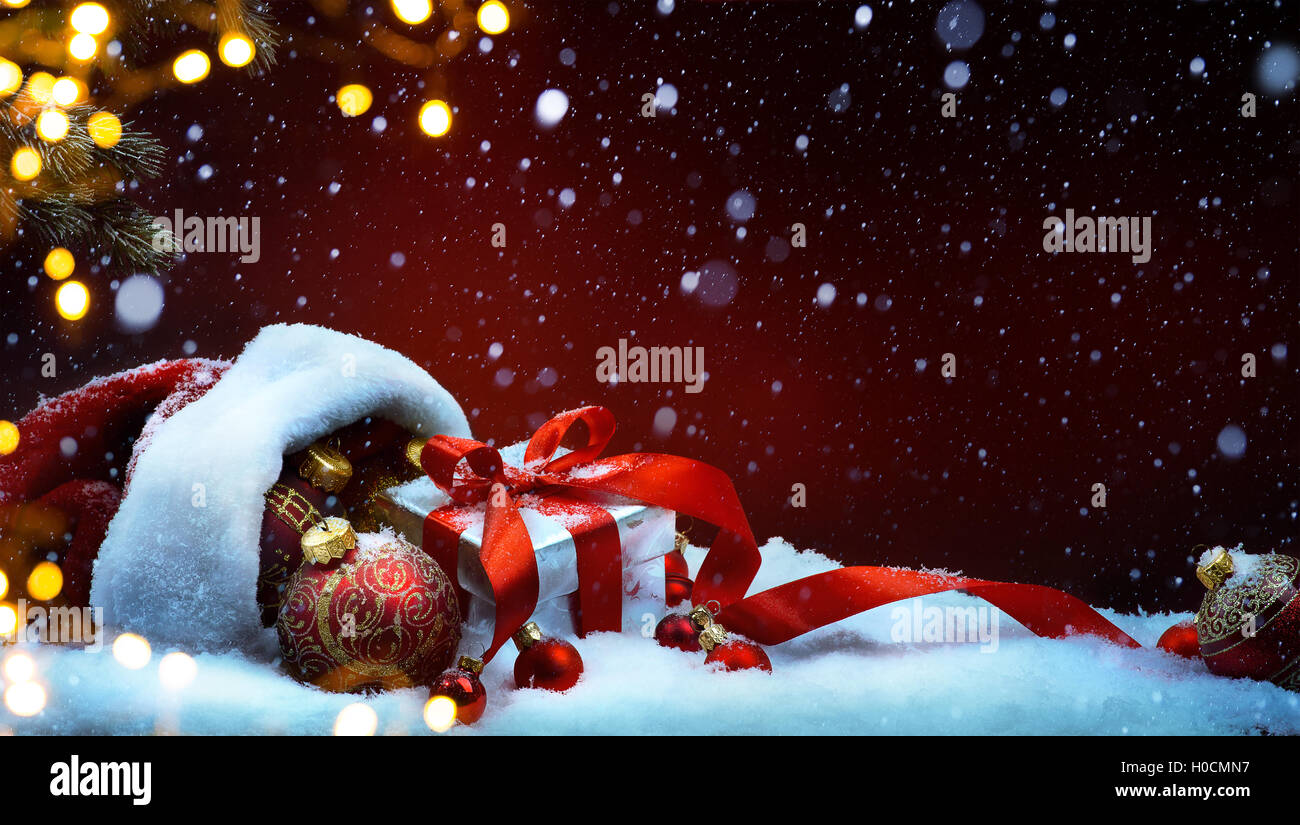 Weihnachtsbaum-Licht; festlichen Hintergrund mit Christbaumkugeln und Geschenk-Box auf Schnee Stockfoto