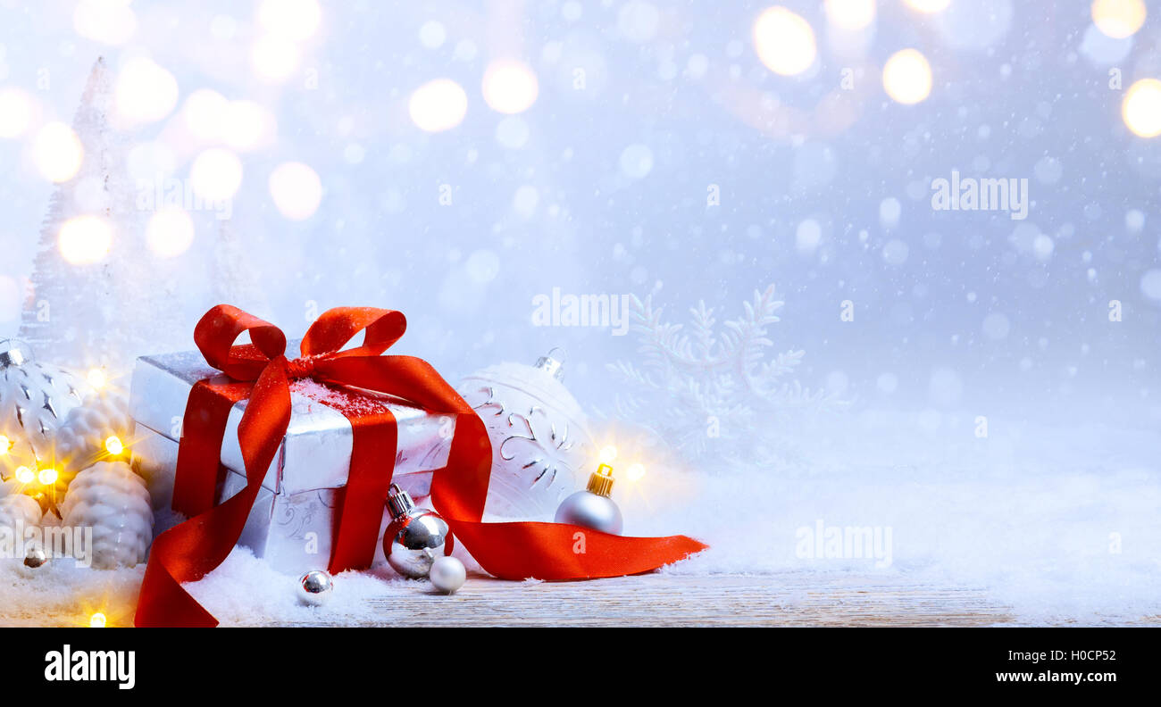 Weihnachtsbaum-Licht; festlichen Hintergrund mit Christbaumkugeln und Geschenk-Box auf Schnee Stockfoto