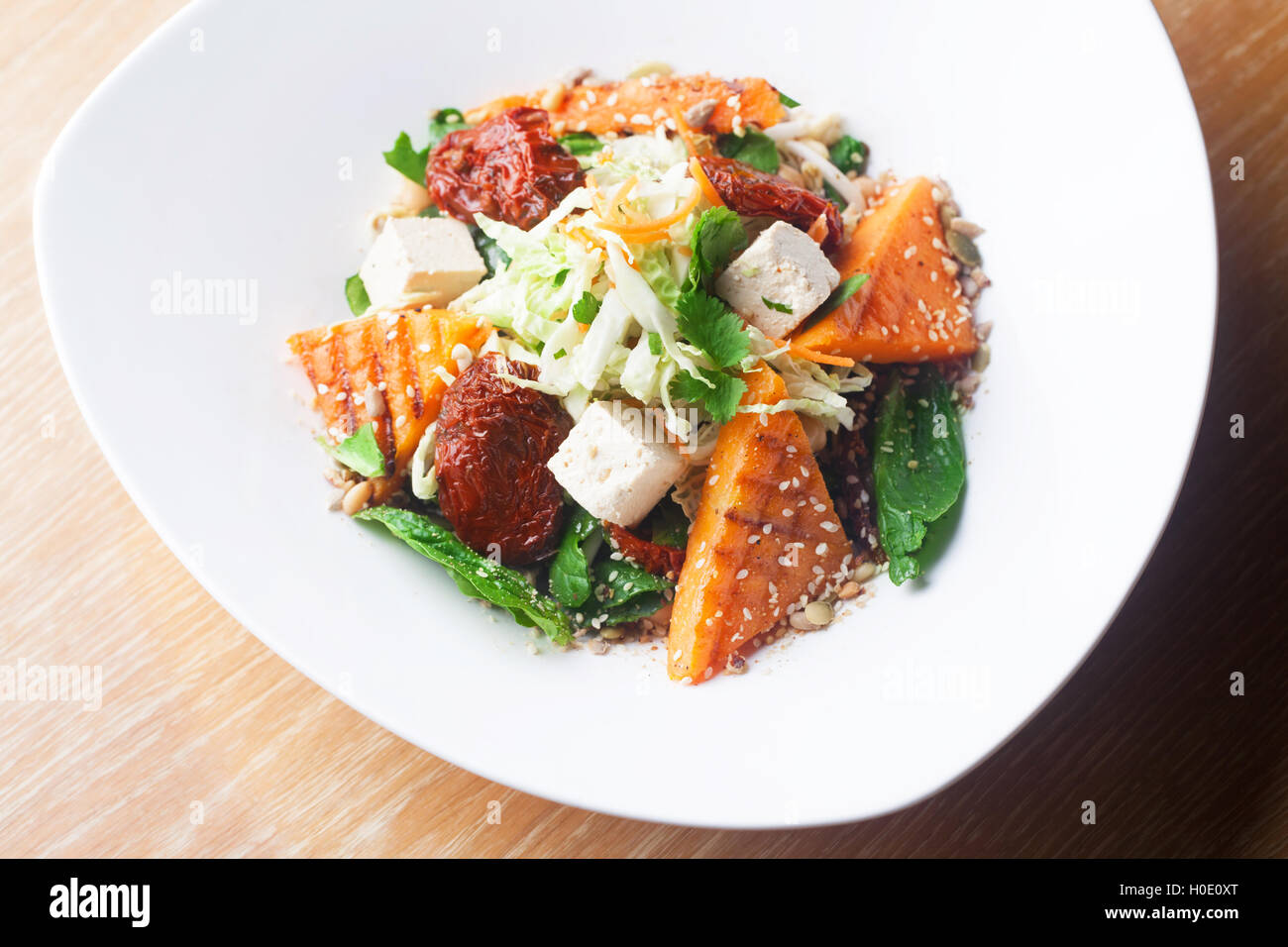 Salat mit Kürbis und Kichererbsen auf weißen Teller Stockfoto