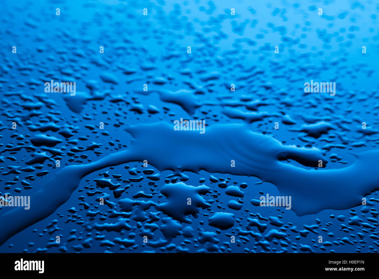 Wassertropfen auf dunklen blauen Oberfläche Stockfoto