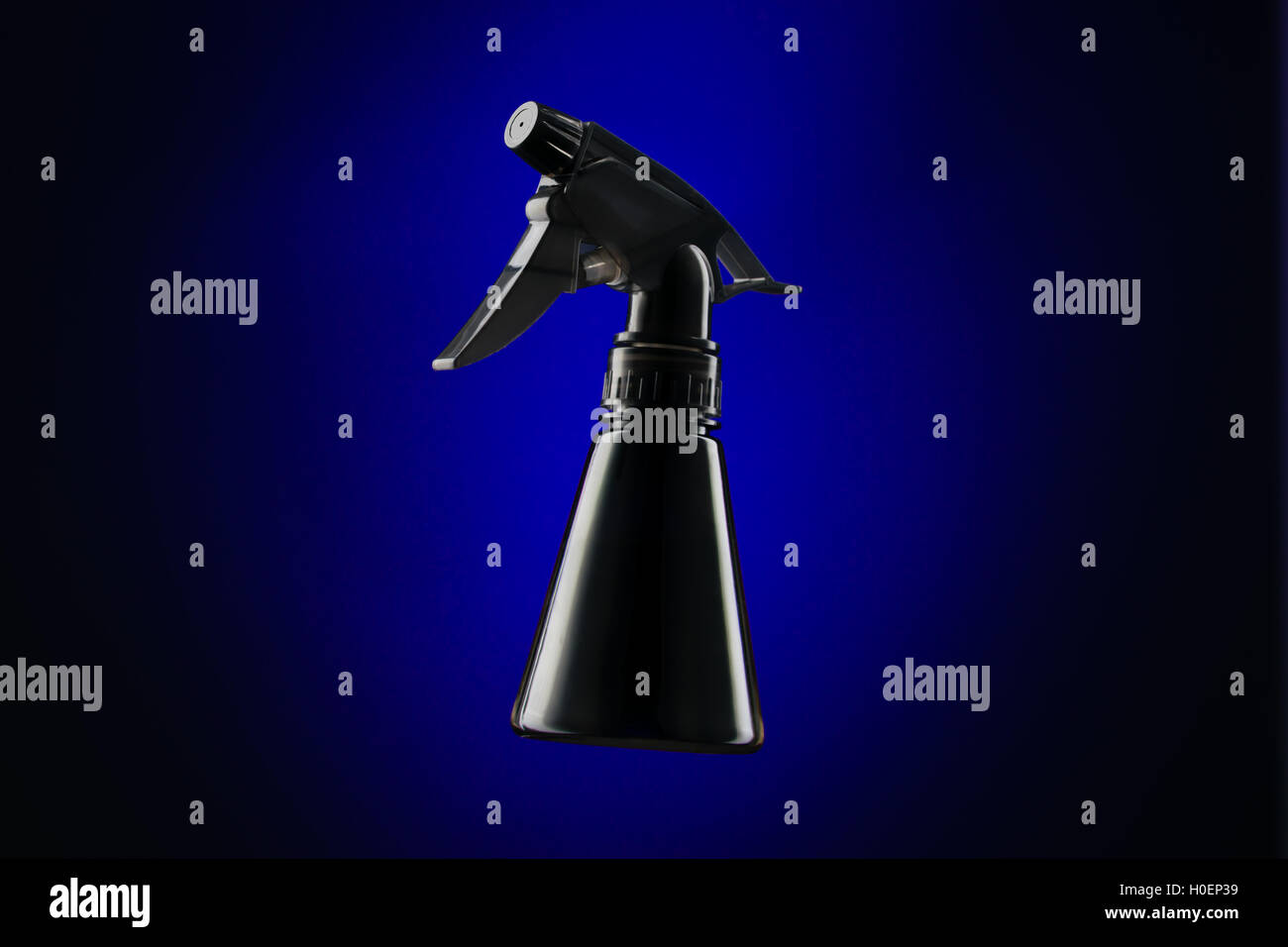 Schwarzer Mini Sprühflasche auf blauem Hintergrund Stockfoto