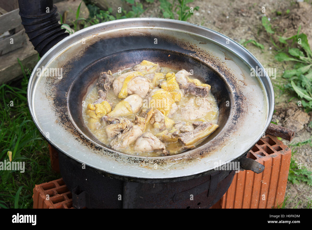 Fleisch kochen im Freien auf improvisierten Grill gemacht aus Ziegeln Stockfoto