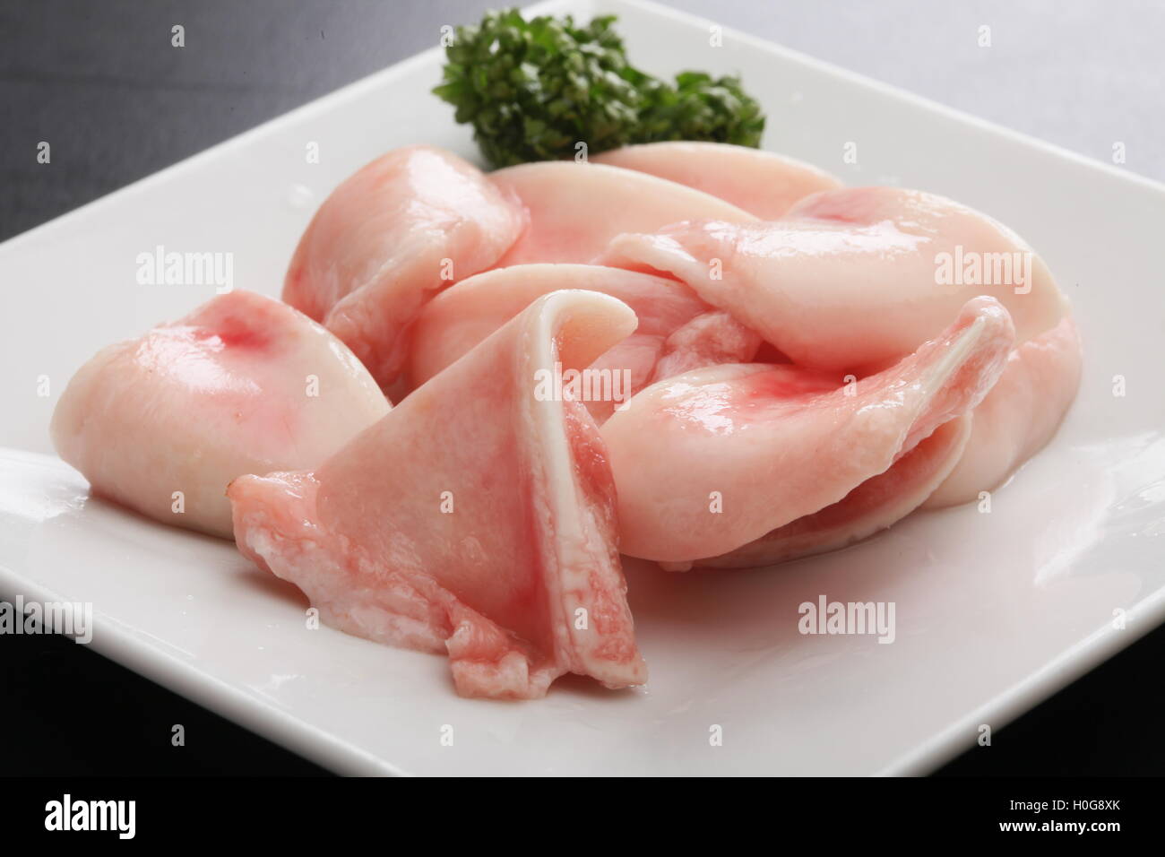 Frische rohe Schweinefleisch Knorpel mit Kreuzkümmel Kräuter auf weißem Teller Stockfoto