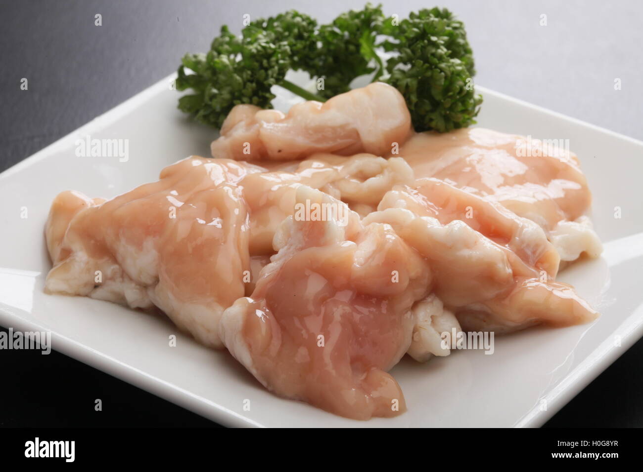 Spezialität frische Salz Hormon Schwein Magen mit Kreuzkümmel auf weißem Teller Stockfoto