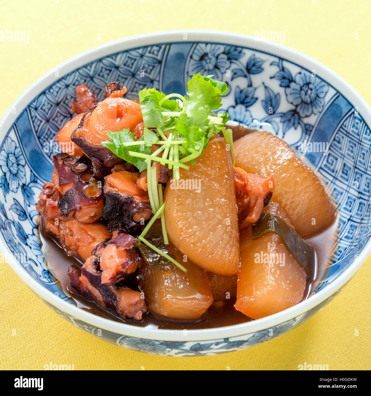 Sautierte Tintenfisch mit weißer Rettich und Kreuzkümmel Kräuter in traditionellen japanischen Schüssel Stockfoto