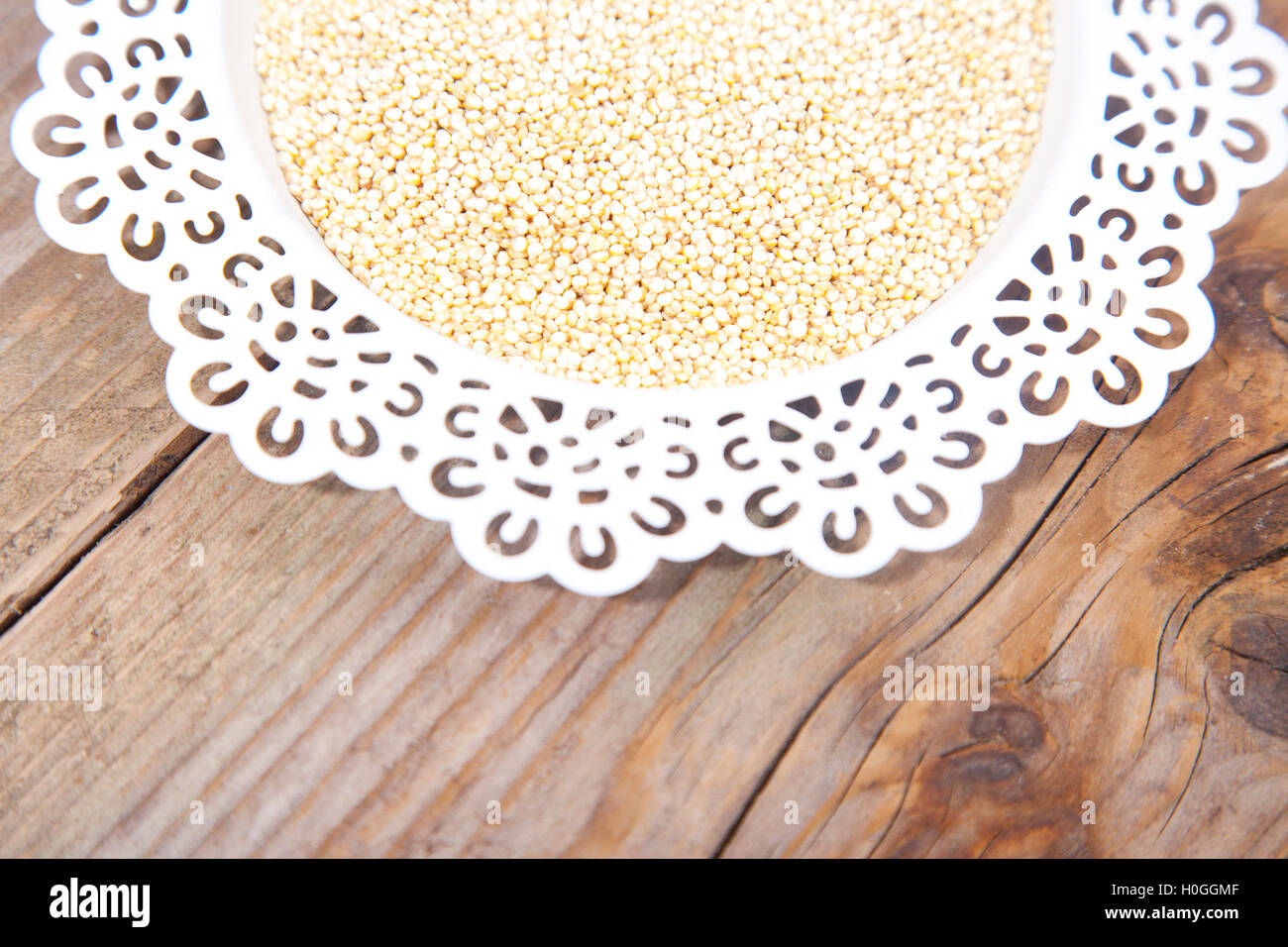 Weiße Quinoa auf weißen Teller auf braunem Holz Hintergrund Stockfoto