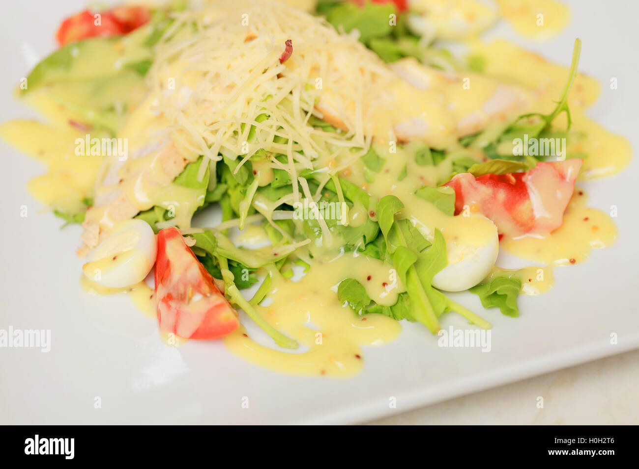 Salat mit Eiern, Tomaten, Hähnchen und Käse Stockfoto