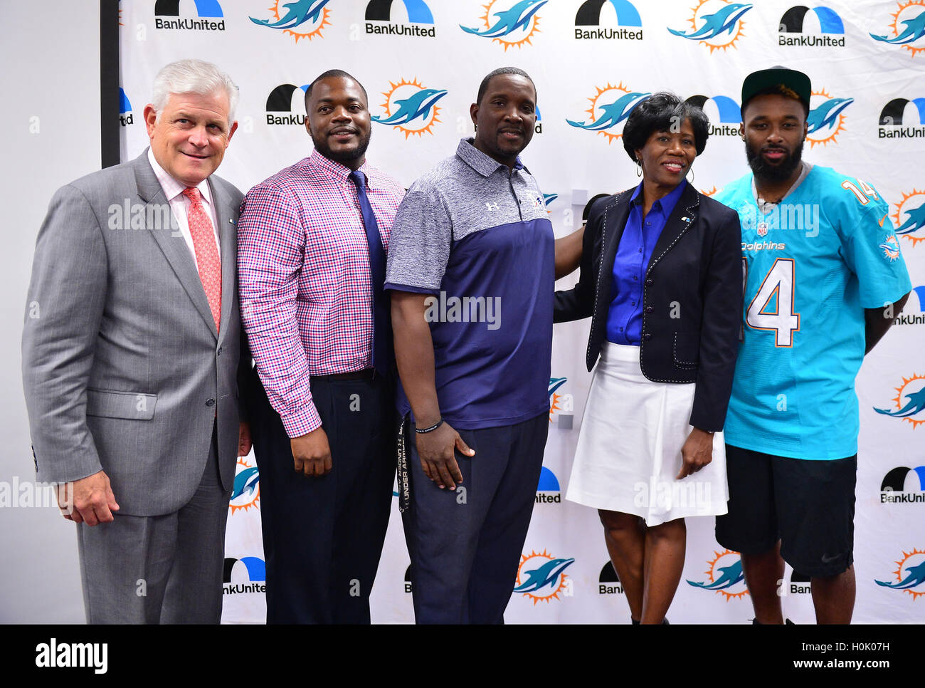MIAMI, FL - 20. SEPTEMBER: BankUnited Senior Executive Vice President Gerry Litrento, Miramar High School Athletic Director Alex Francois, Miramar High School Coach Pierre Senatus, BankUnited Vice President of Community Development & Outreach Katrina Wright und Miami Delphine Wide Receiver (#14) Jarvis Landry Überraschung die Miramar Patrioten Varsity Football team vor das Team der Praxis im Rahmen der 4 Downs für Finanzen finanzielle Allgemeinbildung Programm gesponsert von BankUnited. Landry teilen seine Gedanken über die Bedeutung der finanziellen Allgemeinbildung im Miramar High School Media Center am 20 September 201 Stockfoto