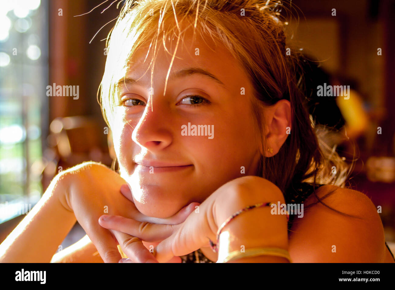 Teenager auf der Suche Inhalt Kinn auf überquerte Hände Gold warmes Licht Stockfoto