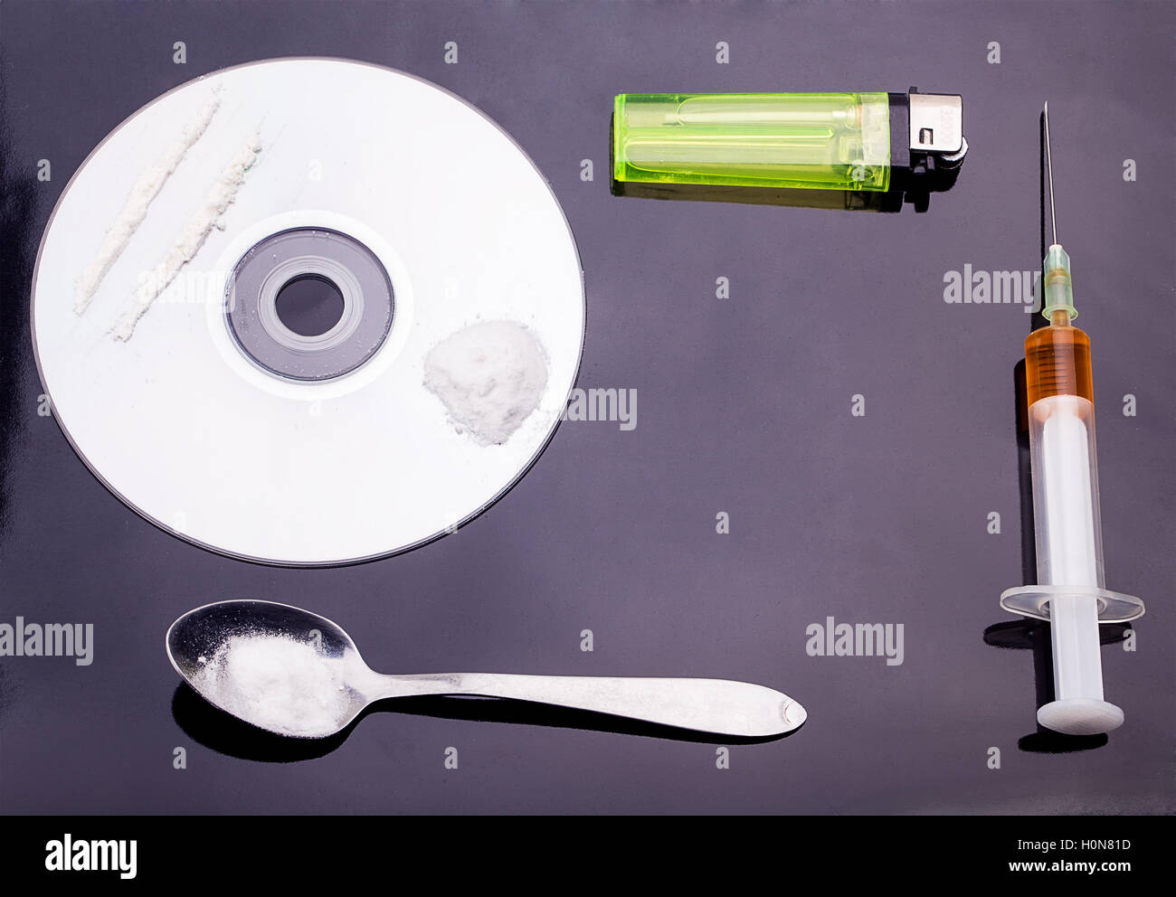 Сocaine in das DVD-Laufwerk mit einem Löffel, leichter und Spritze auf schwarzem Hintergrund Stockfoto