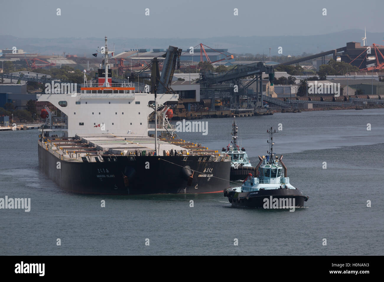 Voll beladen, Bulk Carrier Amakusa Insel verlassen den Hafen von Newcastle von drei Schlepper Newcastle Australien unterstützt Stockfoto