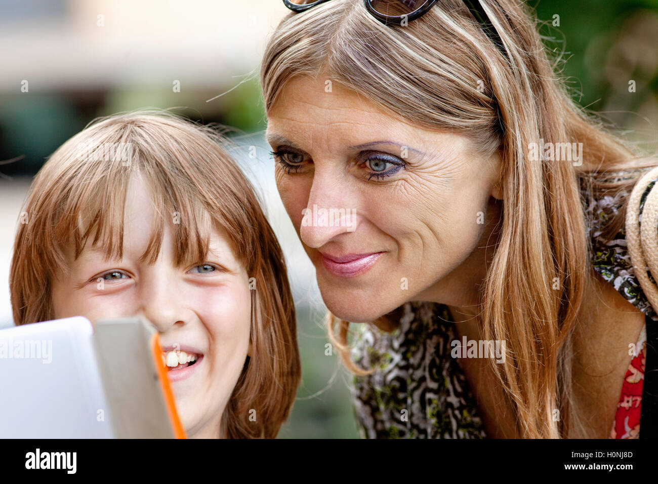 Jungen zeigen etwas Mutter auf Tablet Stockfoto
