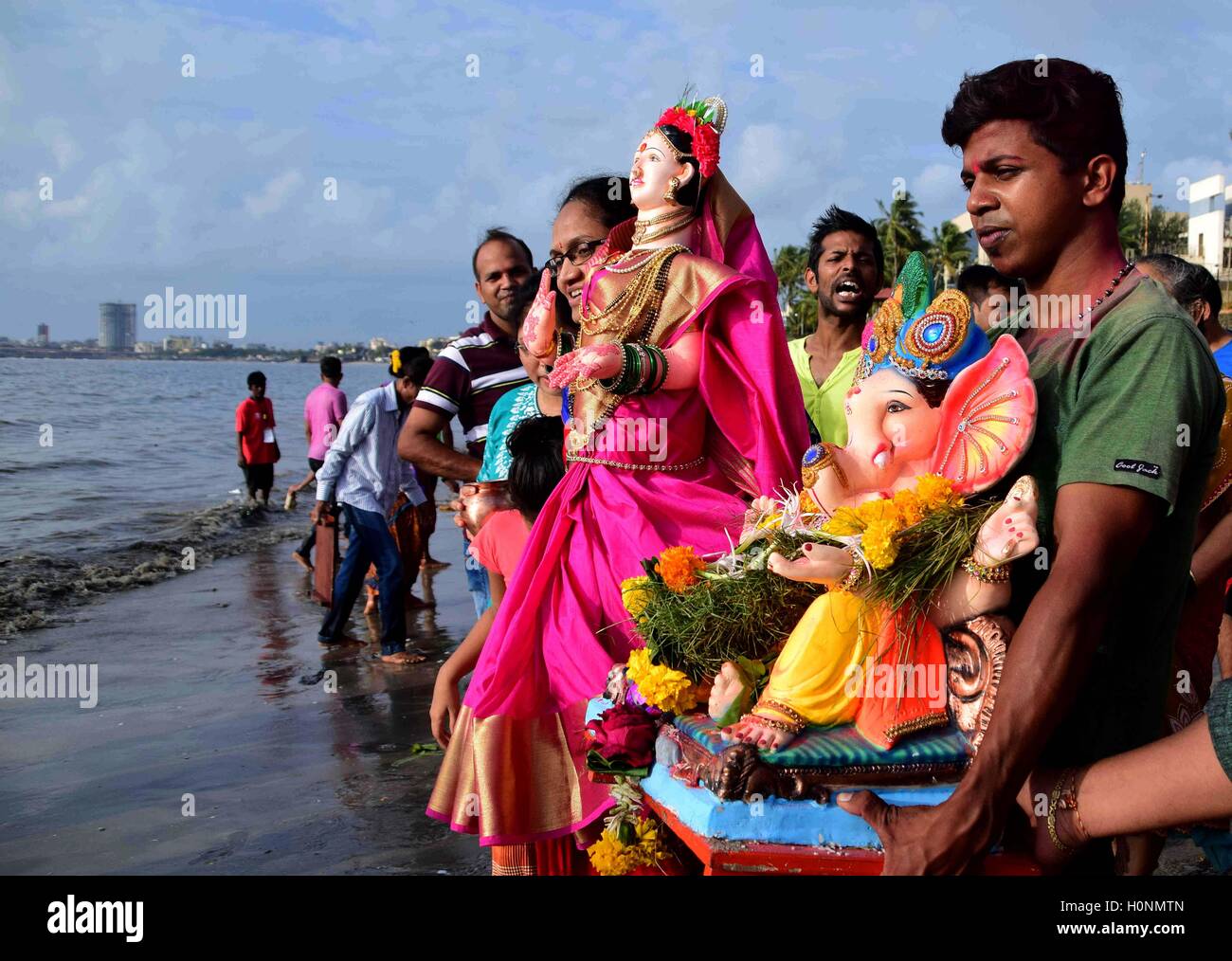 Anhänger tragen eine Ton-Idol der elefantenköpfige Hindugott Ganesha, für das Eintauchen in das Arabische Meer in Mumbai, Indien Stockfoto