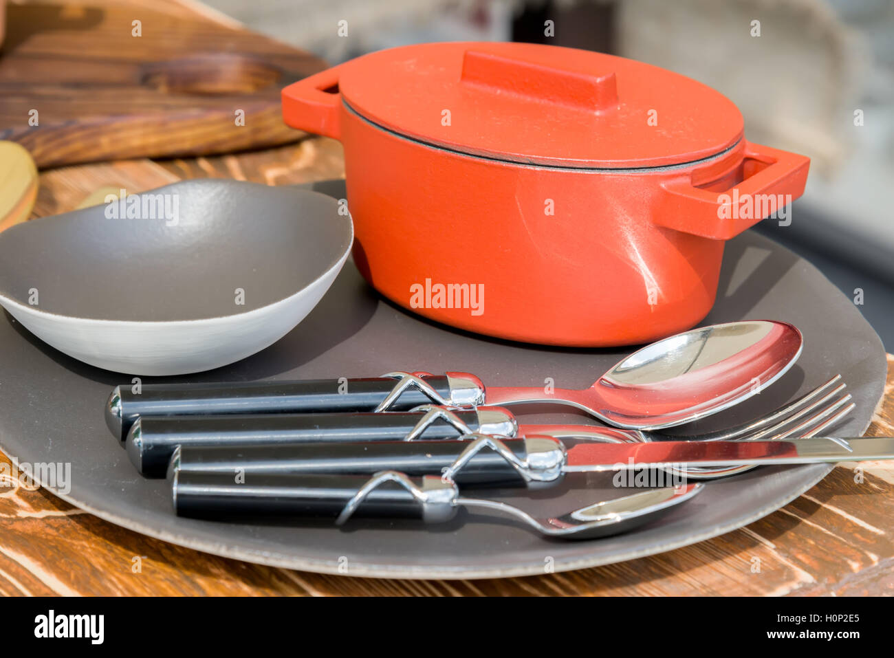 neue moderne gusseisernen Kessel und Küchengeräte auf einem Teller Stockfoto