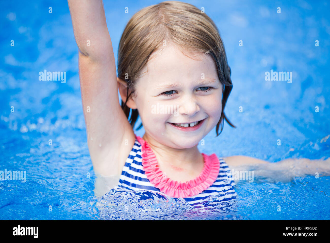 kleines Mädchen im Pool stehen Stockfoto