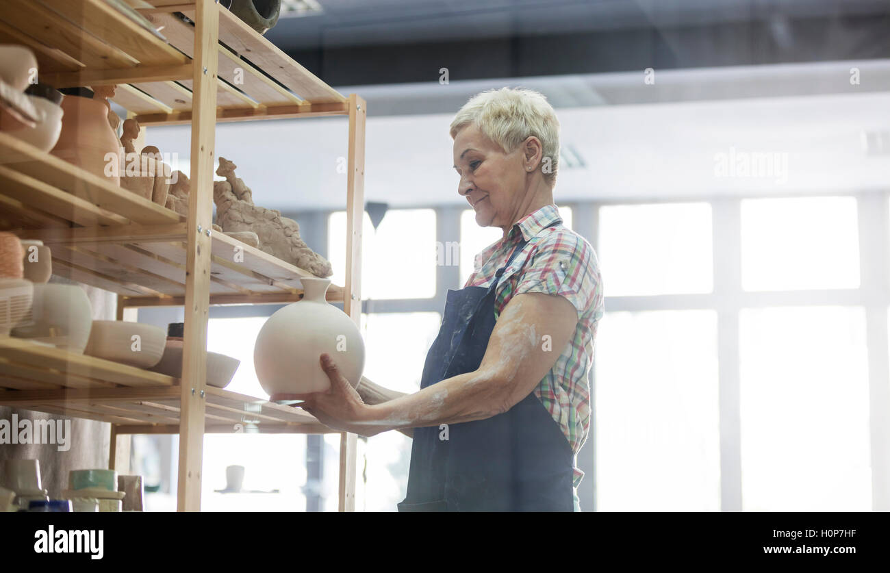 ältere Erwachsene Frau Keramikatelier Vase Regal Stockfoto