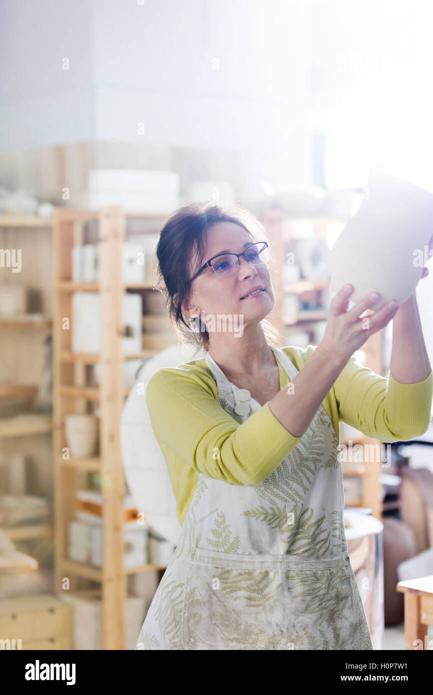 reife Erwachsene Frau Prüfung Vase Keramikatelier Stockfoto