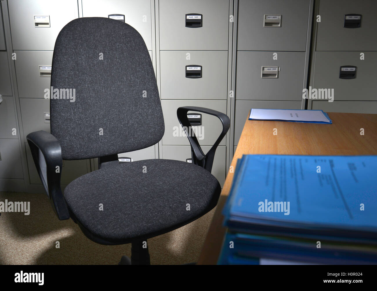 einen einzelnen Bürostuhl in leeren Büro mit Aktenschränke Stockfoto