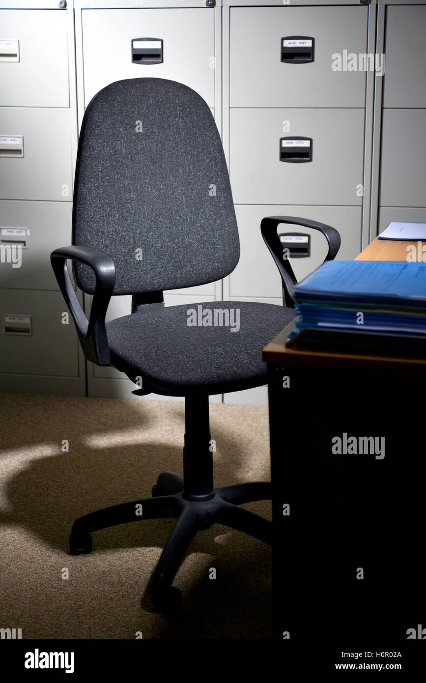 einen einzelnen Bürostuhl in leeren Büro mit Aktenschränke Stockfoto