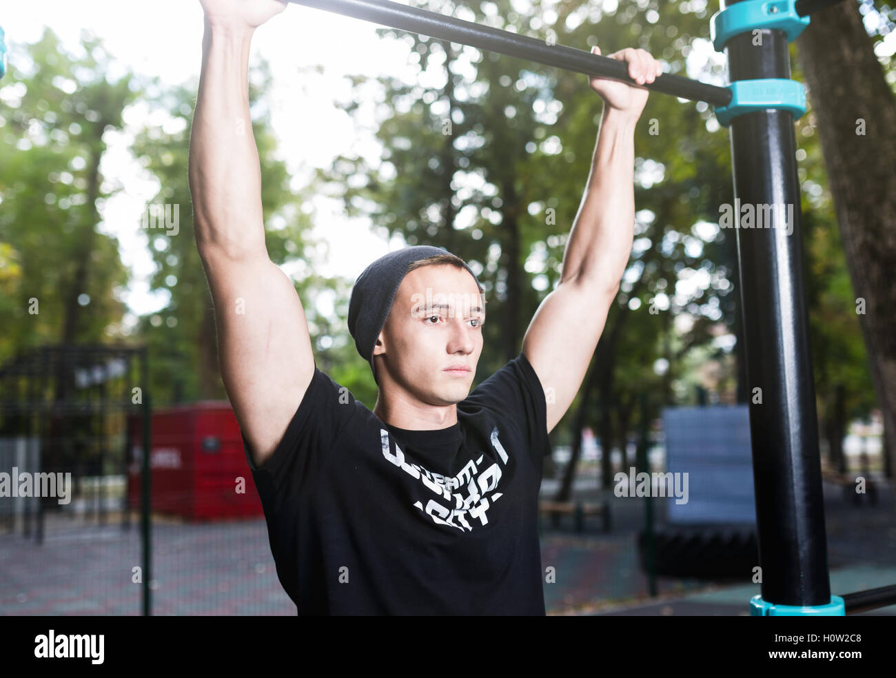 Junger Mann tun Pull Ups auf horizontale Leiste im Freien, Training, Sport-Konzept Stockfoto