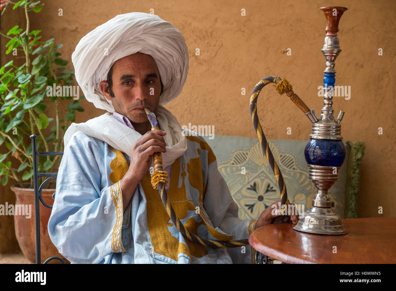 In der Nähe von Ait Oudinar, Dades Schlucht, Marokko.  Berber Jüngling Rauchen einer Wasserpfeife (Shisha). Stockfoto