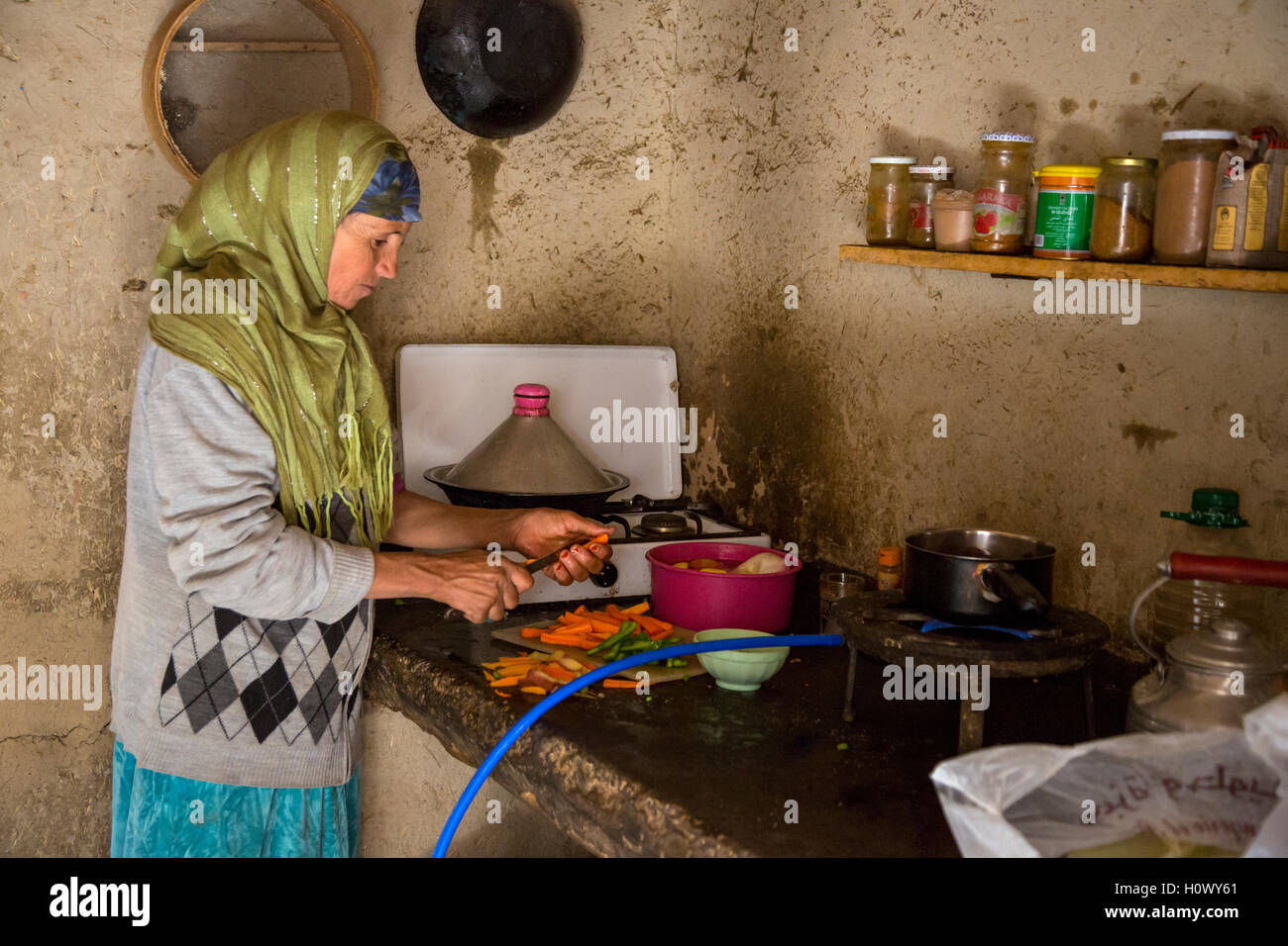 Dades Schlucht, Marokko.  Mittleren Alters Berber Frau Vorbereitung Abendessen in ihrer Küche. Stockfoto