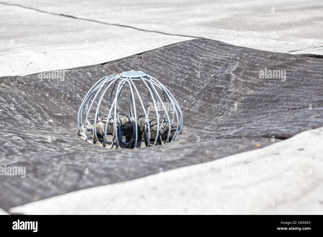 auf ein Flachdach ist Abfluss, um gegen Blätter halten Stockfoto