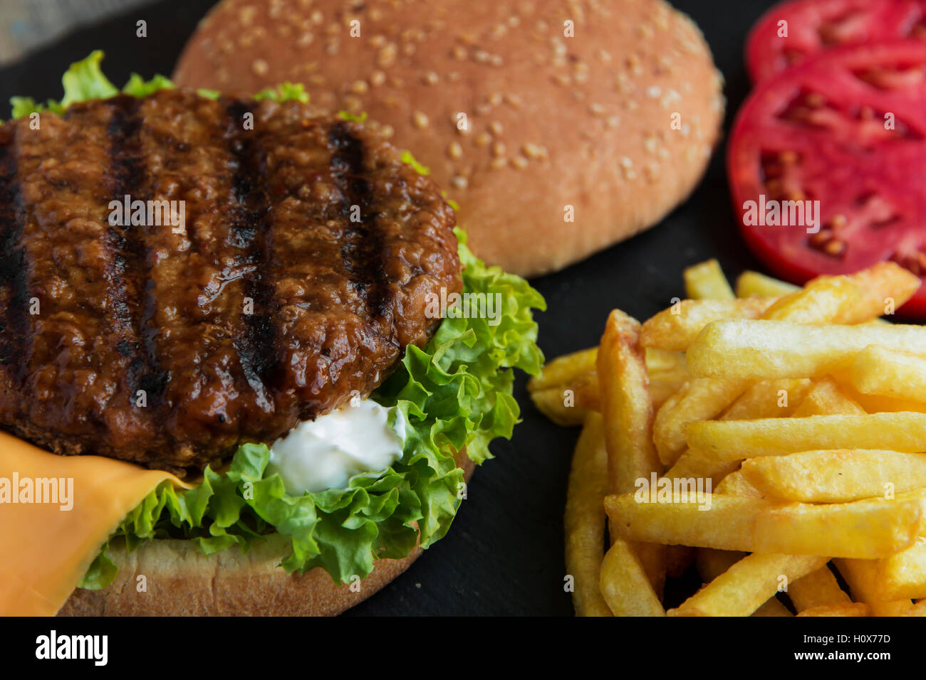 Rindfleisch-Hamburger-Grill-Pommes-frites eingelegte Gurken-Tomaten-Käse Stockfoto
