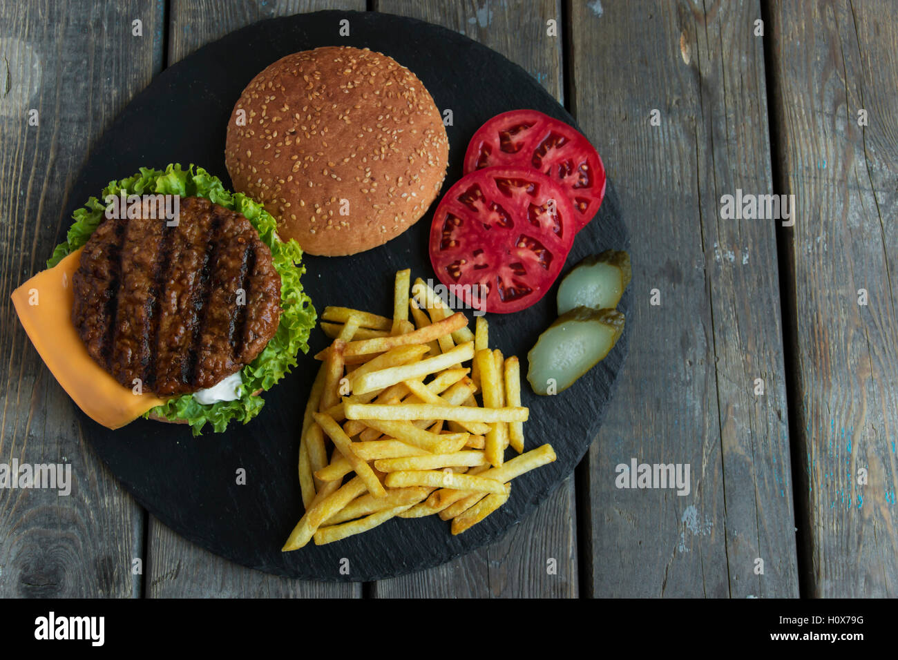 Rindfleisch-Hamburger-Grill-Pommes-frites eingelegte Gurken-Tomaten-Käse Stockfoto