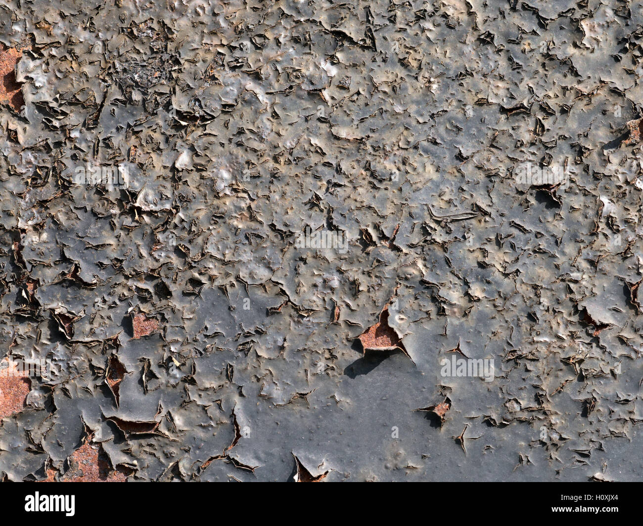 Schwarz, abblätternde Farbe auf eine rostige Oberfläche. Textur Detail hautnah. Stockfoto