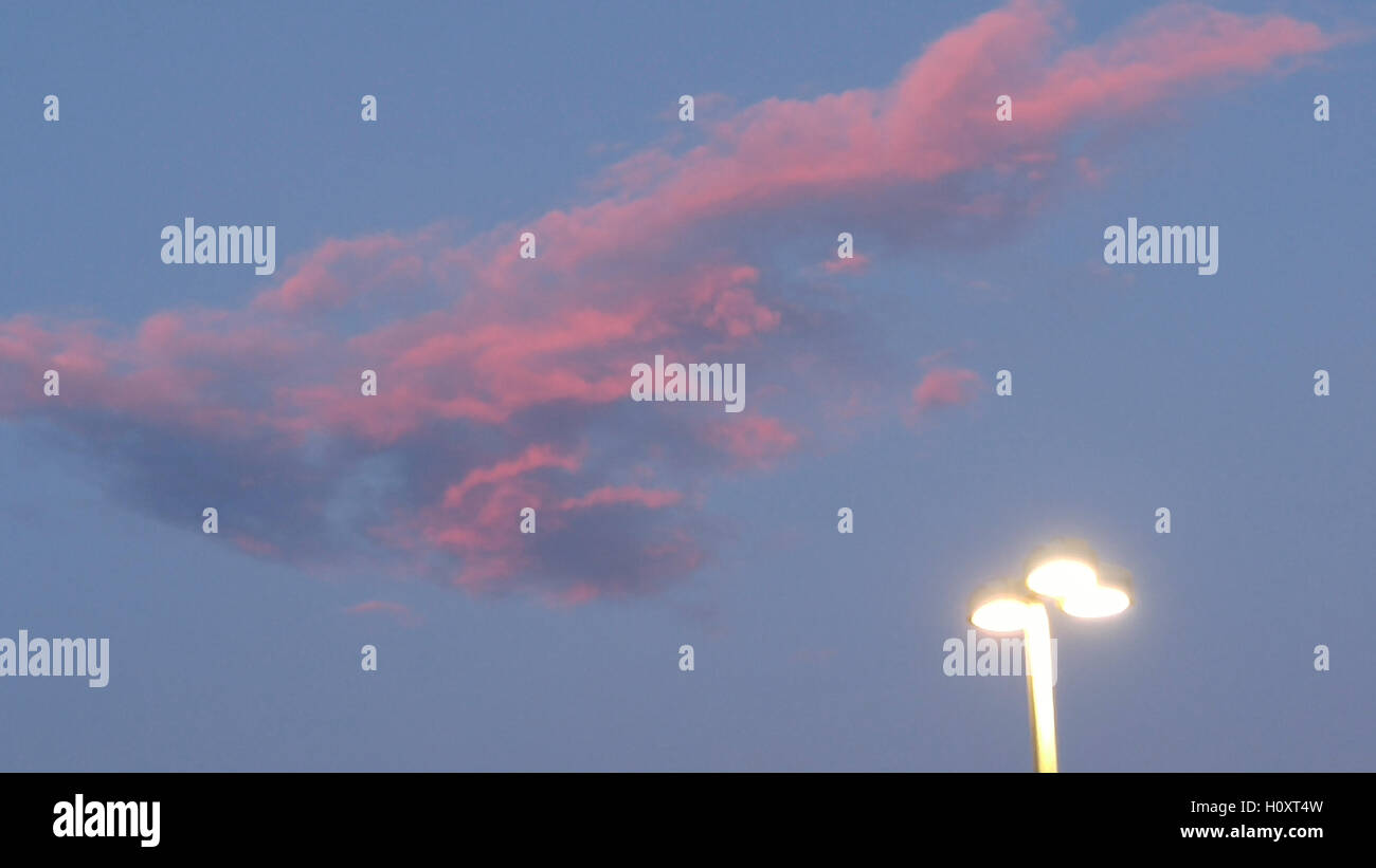 Rote Wolken und Straßenlaterne in dunkelblauen Himmel bei Sonnenuntergang Stockfoto