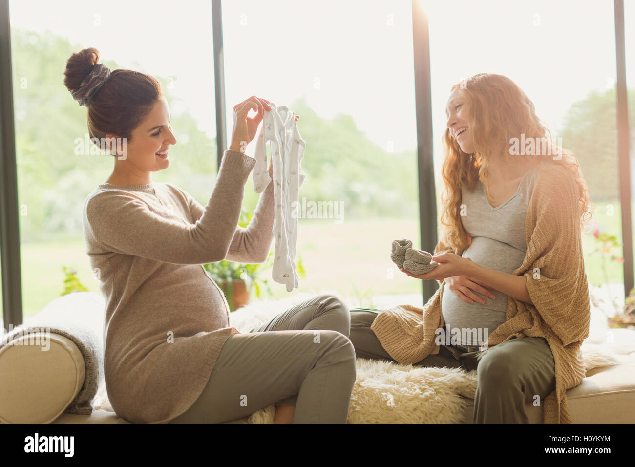 Schwangere Frau mit Baby Kleidung Freund Stockfoto