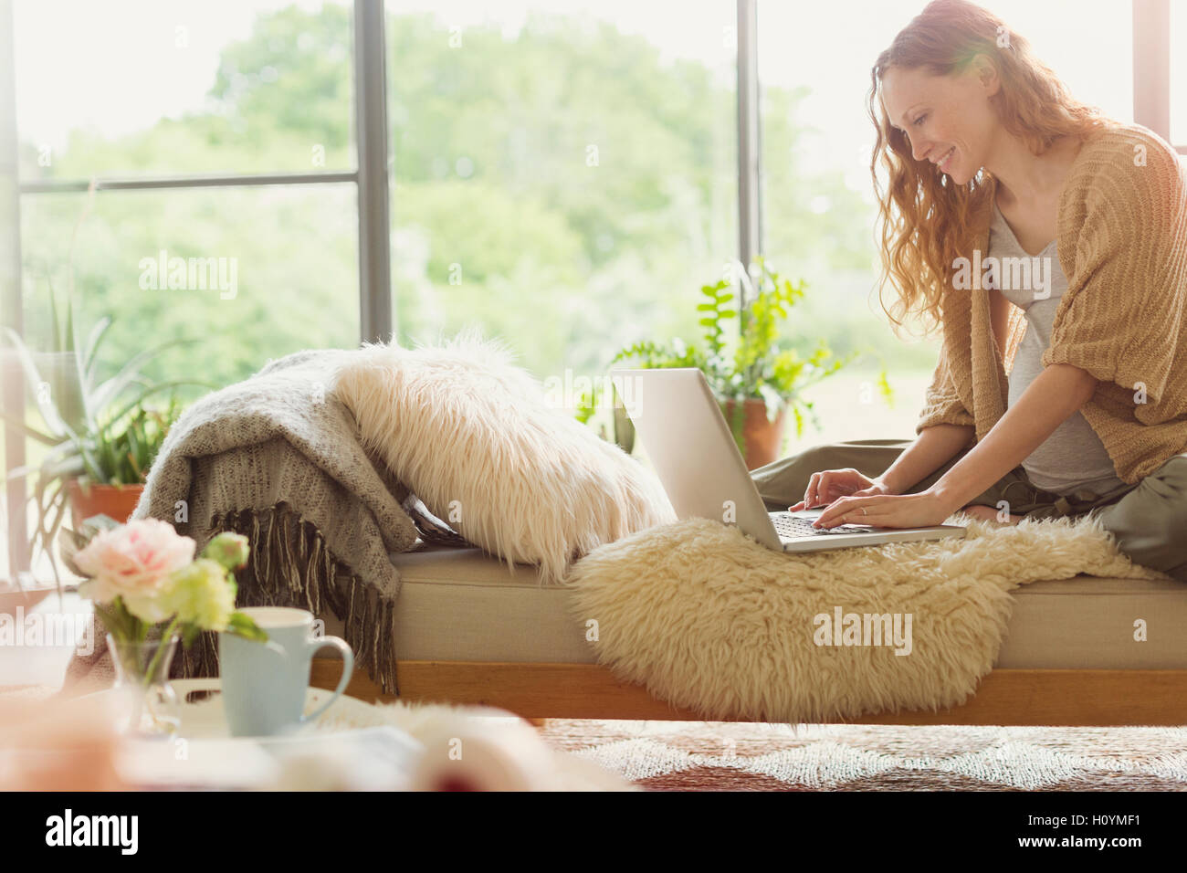 Schwangere Frau mit Laptop Lounge Wohnzimmer Stockfoto