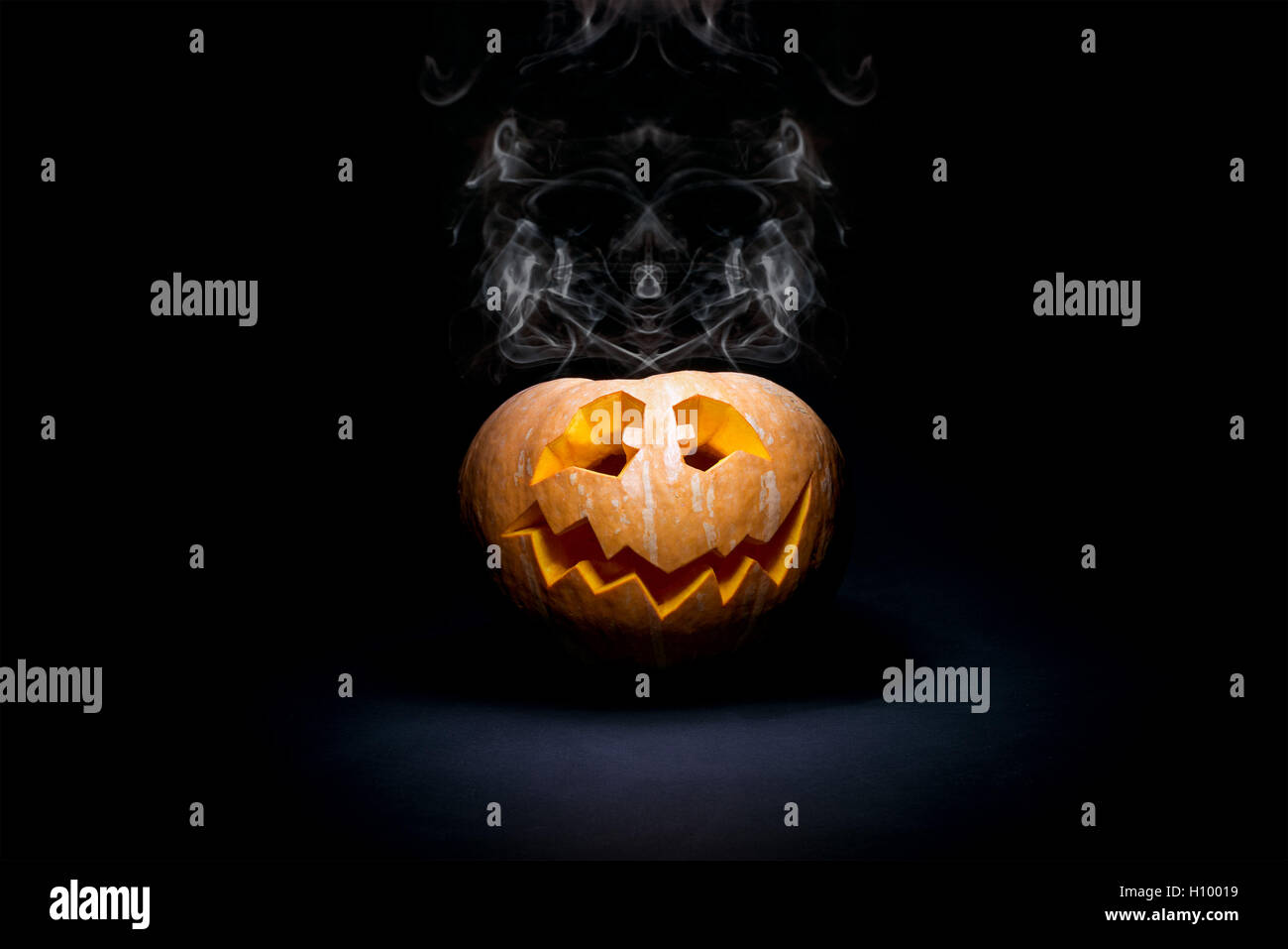 Halloweenkürbis Grimasse auf schwarzem Hintergrund Stockfoto