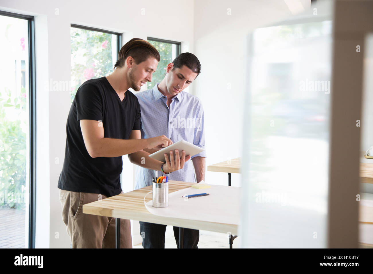 Zwei männliche Büroangestellte diskutieren Ideen in einem modernen Büro Stockfoto