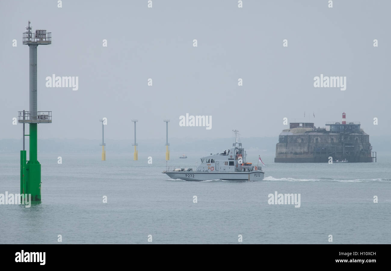 HMS Smiter (P272) Segel aus Portsmouth Hafen vorbei an die Navigation leicht Pfähle, die in den Solent installiert wurden. Stockfoto