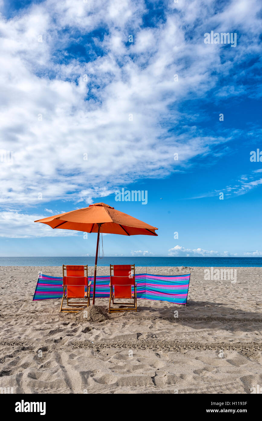 Liegestühle und Sonnenschirm am Strand Stockfoto