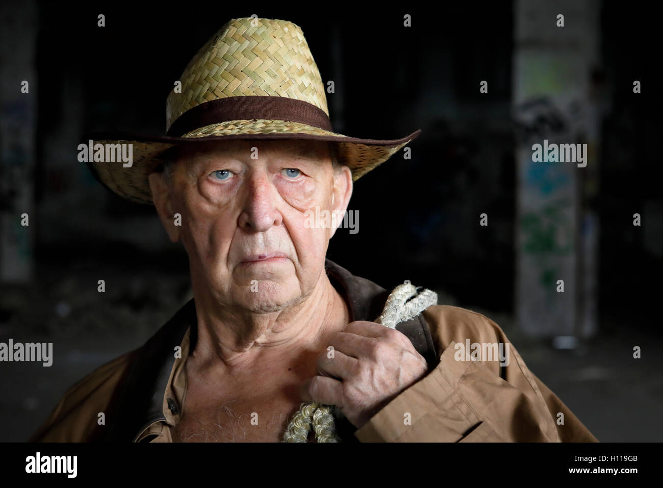 Senior Schauspieler Abenteuer Mann 80 posiert mit einem Strohhut und einem Seil schließen sich heroisch erschossen Stockfoto