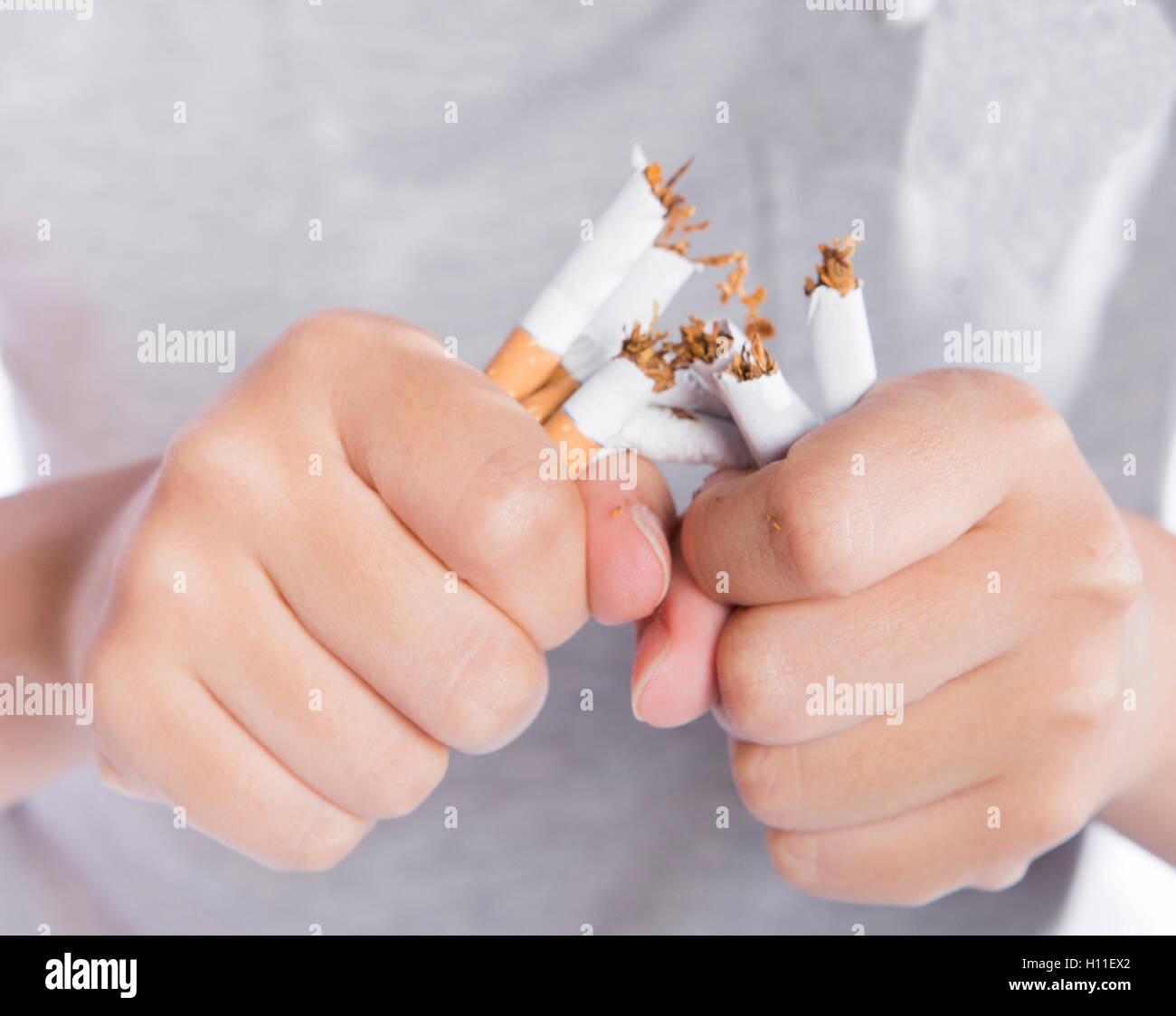 Nicht mehr rauchen, Nahaufnahme von Mädchen in grauen T-shirt brechen Zigaretten aus gesundheitlichen Grund gebrochen Zigarette in der hand. Stockfoto